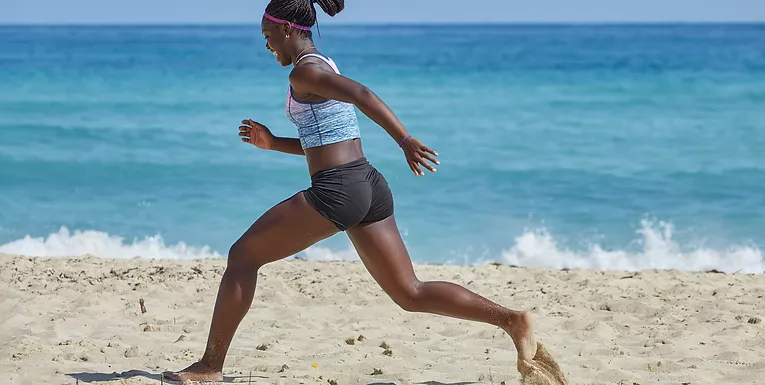 woman running happily on a beach